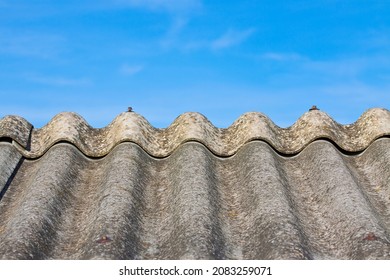 Old aged dangerous asbestos roof made of concrete panels - one of the most dangerous materials in buildings so-called ‘hidden killer’ 