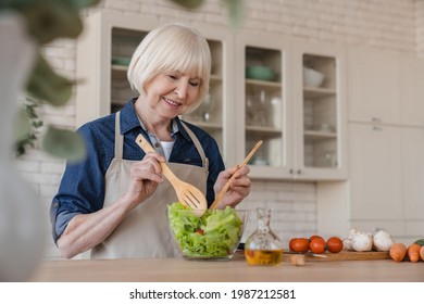 Old aged elderly senior caucasian woman grandmother mixing ingredients in vegetable salad, cooking healthy food at home, preparing meal at home. Dieting and active seniors concept - Powered by Shutterstock