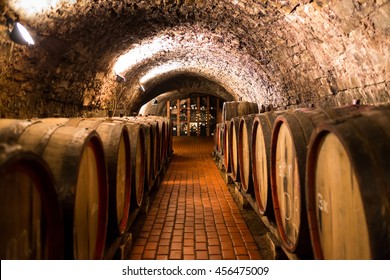 Old aged traditional wooden barrels with wine in a vault lined up in cool and dark cellar in Italy, Porto, Portugal, France 