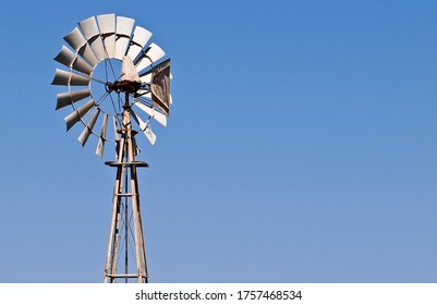 Old Agricultural Wind Mill Over Blue Sky