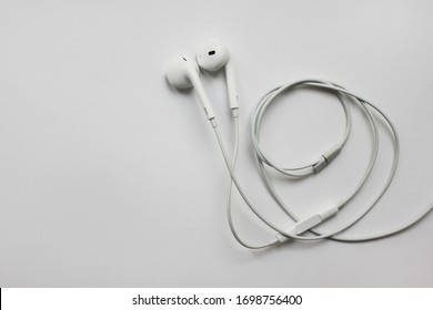 Old Air Pods Wired White Headphones Isolated On The Table In Moscow On April 2020. Simple Small Wired Apple Company Headphones, Classic Airpods Accessories For IPhone, IPad And IPod For Music 