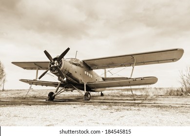 Old airplane on field in sepia tone