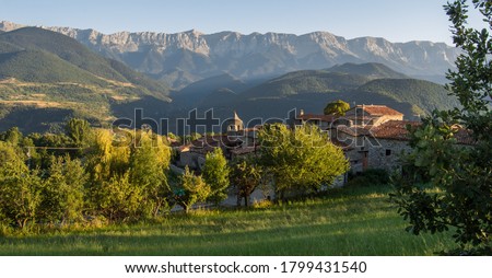 Old alpine village called Travesseres with an imposing mountain chain in the background at golden hour. Beautiful panorama in Serra del Cadi, Pyrenees, in Catalonia (Catalunya), Spain. 