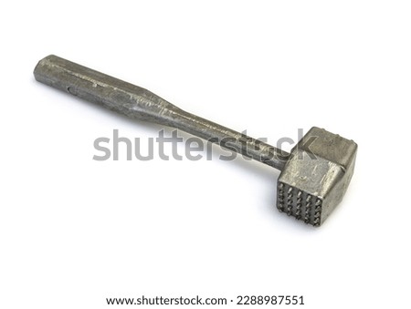 An old aluminum hammer for beating meat on a white background.