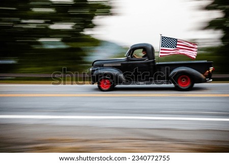 Old American car in motion with American flag 