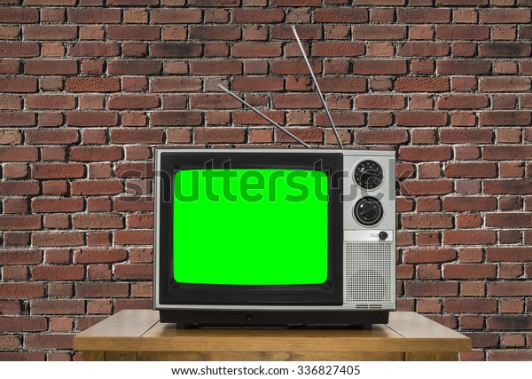 Old analogue television with chroma key green
screen and brick wall.