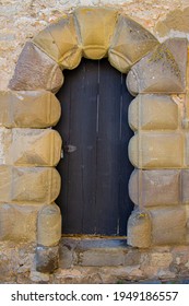 Old Ancient Black Wooden Door Framed With Big Sandstone Archway