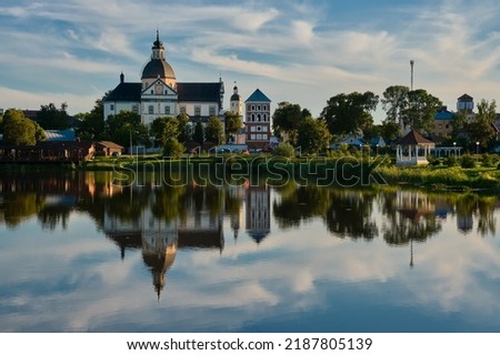 Old ancient Church of Corpus Christi in the evening, Nesvizh, Minsk region, Belarus. Far temple of Body of the Lord with reflection in the lake in Nesvizh city, Belarus.