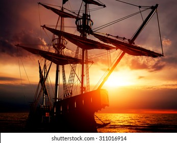 Old ancient pirate ship on peaceful ocean at sunset. Calm waves reflection, sun setting. - Powered by Shutterstock