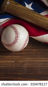 An Old, Antique American Flag With Vintage Baseball Equipment On A Wooden Bench