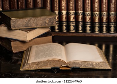 Old Antique Bible Book On A Black Carved Table With Book Stack And Encyclopedia Books In The Background