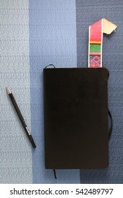 An Old Antique Black Diary, Book, Poetry Book, A Colorful Vintage, Retro Book Mark And A Black Writing Pen;