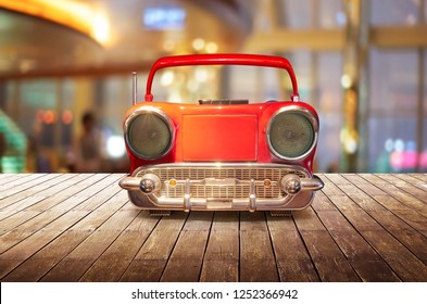 Old Antique Car Shape AM FM Stereo Cassette Player On Wood Table Top With Blur Background