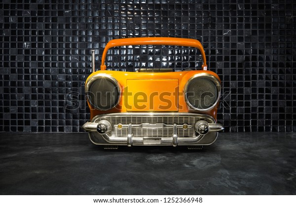 Old antique car shape AM FM stereo cassette\
player on mosaic tiles\
background