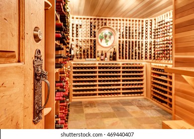 Old antique key lock door know details. Bright home wine cellar with wooden storage units and arch with bottles. Northwest, USA
