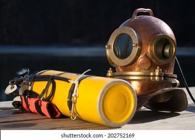 Old antique metal scuba helmet and yellow scuba