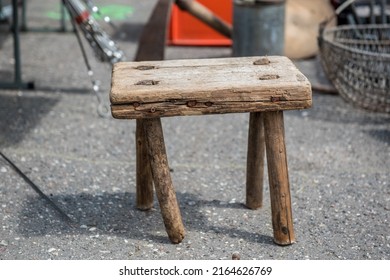 Old antique wooden stool. Old, worn wooden stool. Little stool in a rustic style. Vintage stool seating