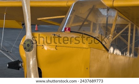 old antique yellow airplane with wooden propeller (close up of cockpit) retro aviation plane detail