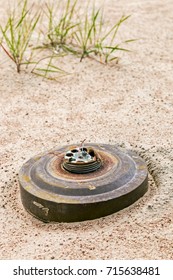 old anti-tank mine buried in the desert sand