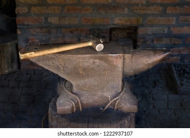 old anvil with a hammer in an old cousin
