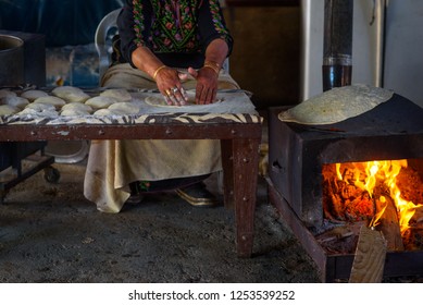 Old Arab Woman Cooking Traditional Bedouin Cuisine Food - Taboon Bread Or Flatbread. Close Up Of Arab Woman Hands Baking Fresh Dough For Taboon Bread Or  Laffa. Middle Eastern And Israel Flat Bread.