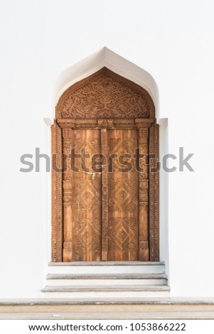 Old Arabian door in white wall in Morocco.
