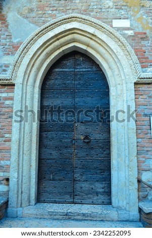 Old arched door of medieval house of Juliet from Romeo and Juliet by W. Shakespeare in Verona city,Northern Italy