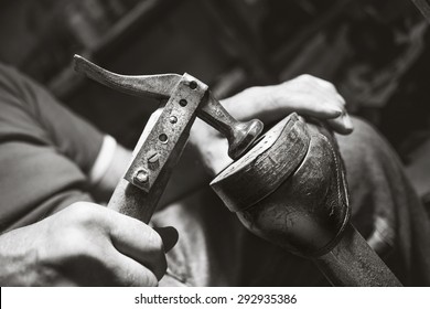 old artisian shoemaker hit shoes with hammer - Powered by Shutterstock