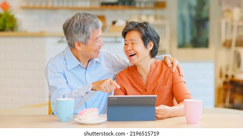 old asian couple sitting together using tablet happily - Powered by Shutterstock