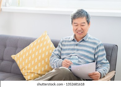 old asian man look somrthing by magnifier at home - Powered by Shutterstock