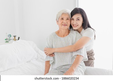 old asian patient sick and admit in hospital, young asian female visiting old female, she hug old female, they feeling happy and smile, elderly healthcare