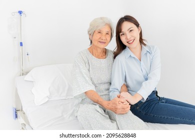 old asian patient sick and admit in hospital, young asian female visiting old female, they holding hands together, they feeling happy and smile, elderly healthcare