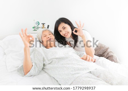 old asian patient and young female show okay sign with hand, she sick and admit in hospital, they feeling happy and smile, elderly healthcare
