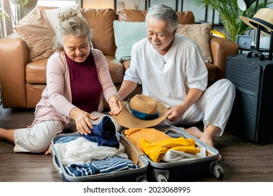 old asian senior couple packing cloth and stuff for a trip together,happiness asian old age retired mature adult enjoy arrange cloth together on floor at living room at home interior background - Powered by Shutterstock