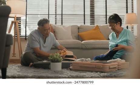 old asian senior couple packing cloth and stuff for a trip together,happiness asian old age retired mature adult enjoy arrange cloth together on floor at living room at home interior background - Powered by Shutterstock