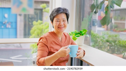 old asian woman having coffee in a cafe happily - Powered by Shutterstock