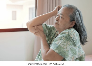 Old Asian woman touching wrist feeling hurt joint pain having osteoarthritis disease. Health problem - Powered by Shutterstock