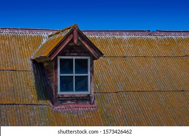 Old Attic Window On The Roof Of A Wooden Farmhouse