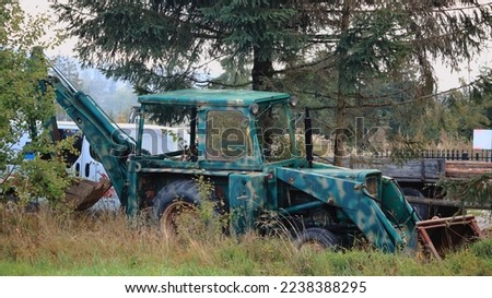 An old backhoe loader standing somewhere among the greenery. Zdjęcia stock © 