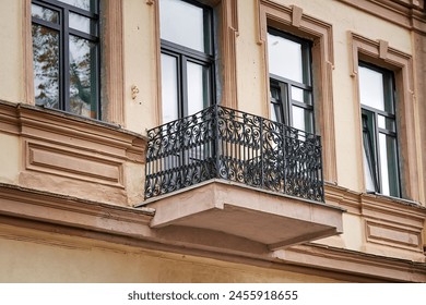 Old balcony with cast iron railing and windows on facade of historic building. Windows and balcony with wrought iron railing. Architectural details of ancient building. Minsk, Revolyutsionnaya street - Powered by Shutterstock