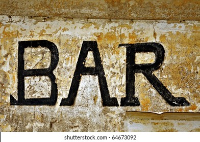 An Old Bar Sign Over A Dirty Wall