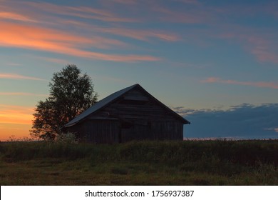 An old barn house against a beautiful midsummer sunset at the rural Finland.