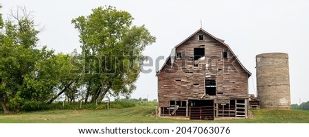 Old Barn and Silo in poor condition in farm country.