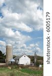 Old barn and silo under a cloudy sky.