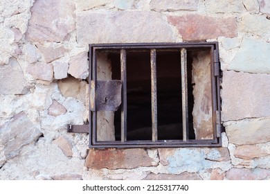 Old barred window- ancient castle fortress dungeon iron bar window - vintage prison watch tower with hinges - medieval stone building- old window with bars