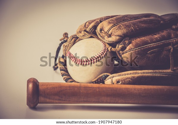 old baseball glove vith\
ball and bat