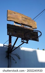 An old basketball hoop made of wood and iron that is starting to become brittle and rusty                         