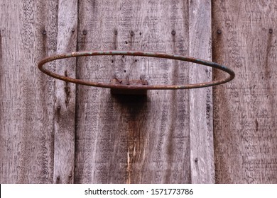 Old basketball hoop on the side of a weathered barn