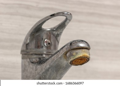 Old Bathroom Sink Faucet contaminated with calcium, grime and rust. Hard water stain build-up.