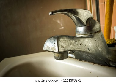 Old Bathroom Sink Faucet, Covered In Grime, Rust, Calcium And Hard Water Stain Build-up.